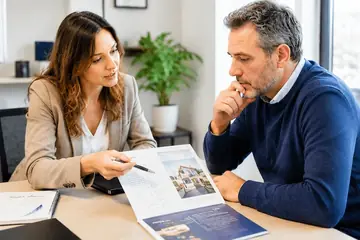 Une femme présente une brochure à un homme qui l’examine