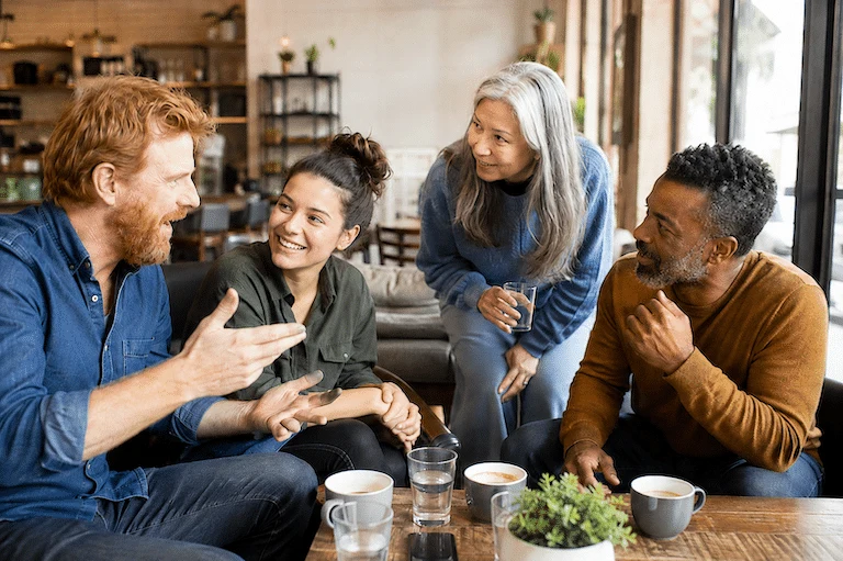Un groupe échange avec enthousiasme autour d’une table